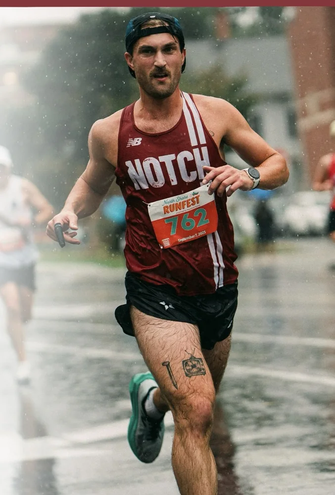 A Notch runner racing in the rain in a club singlet